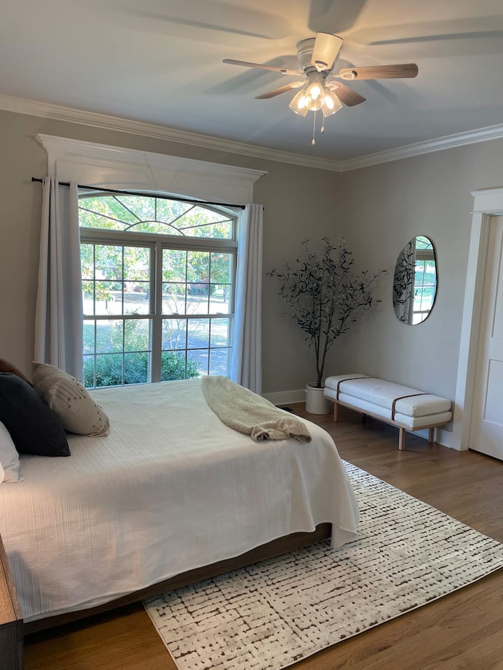 Guest bedroom with queen  bed, walk in closet, and private bathroom vanity. 