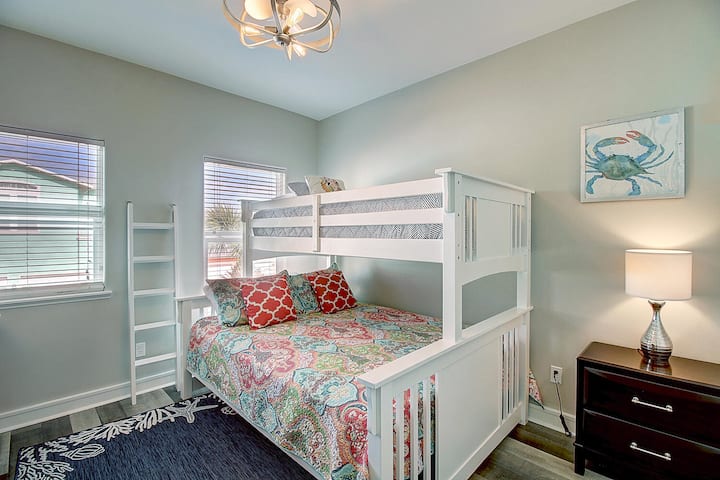 Cozy bunk bed room where kids can drift off surrounded by cheerful coastal decor and soft lighting.