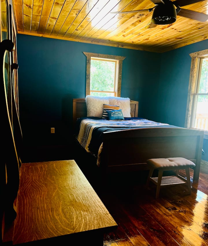 Ამ ოთახში არის საწოლის კომოდი და ტელევიზორი. 