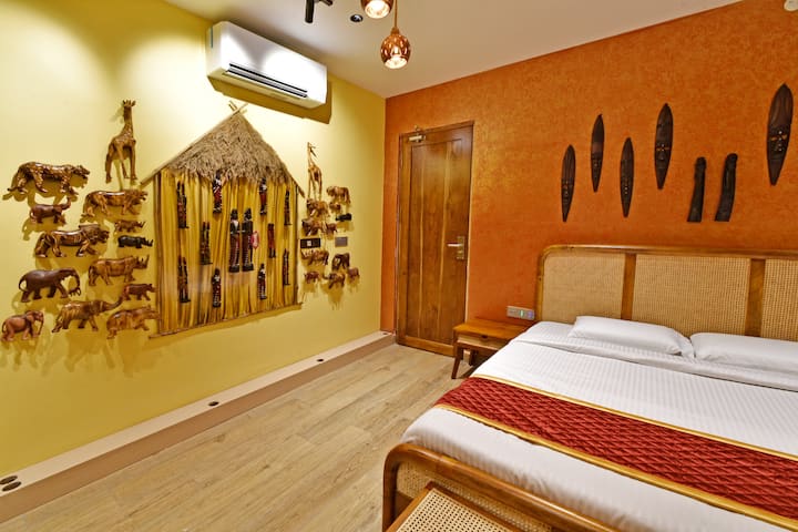 El punto focal de la habitación es una pared bellamente elaborada adornada con animales africanos de madera y una pieza central tradicional inspirada en una cabaña. Esta instalación artística única da vida a la rica cultura de África y ofrece una experiencia verdaderamente inmersiva.