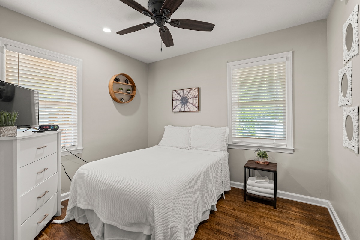 Derde kamer met een queensize bed en een tv, met een plafondventilator en een kast