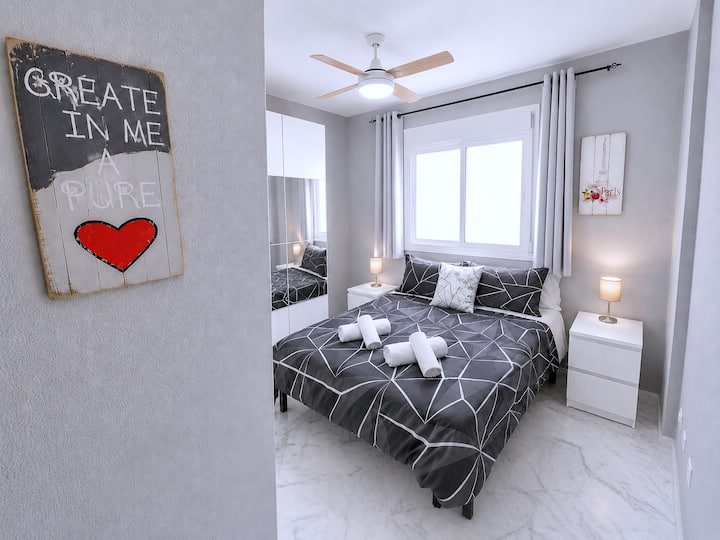 Andet soveværelse med en 1,50 x 1,90 m (queensize) seng, håndklæder, et stort skab med spejle og bøjler og en loftventilator med fjernbetjening og dæmpbart lys samt udsigt over poolen.