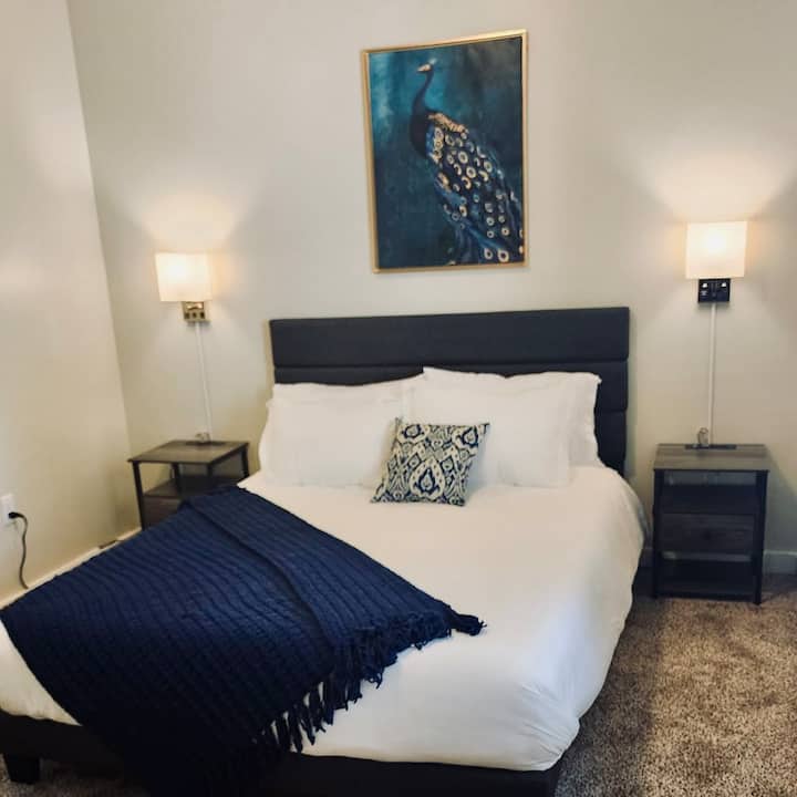 Გასაოცარი საძინებელი ხრაშუნა თეთრი თეთრეულით, ღრმა ფლოტის აქცენტებითა და ელეგანტური დეკორით. Ფარშევანგის რეგალური ნახატი მომხიბვლელობას სძენს, ხოლო ტუმბოებისა და რბილი განათების შესატყვისი საცხოვრებელი იდეალურია მშვიდი ღამეებისთვის.