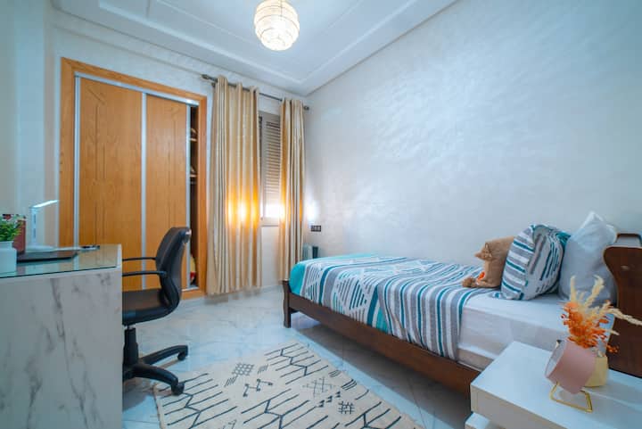 modernt rum, perfekt för en avkopplande vistelse. Rummet är inrett med neutrala nyanser och mjuk belysning, vilket skapar en lugnande atmosfär. 