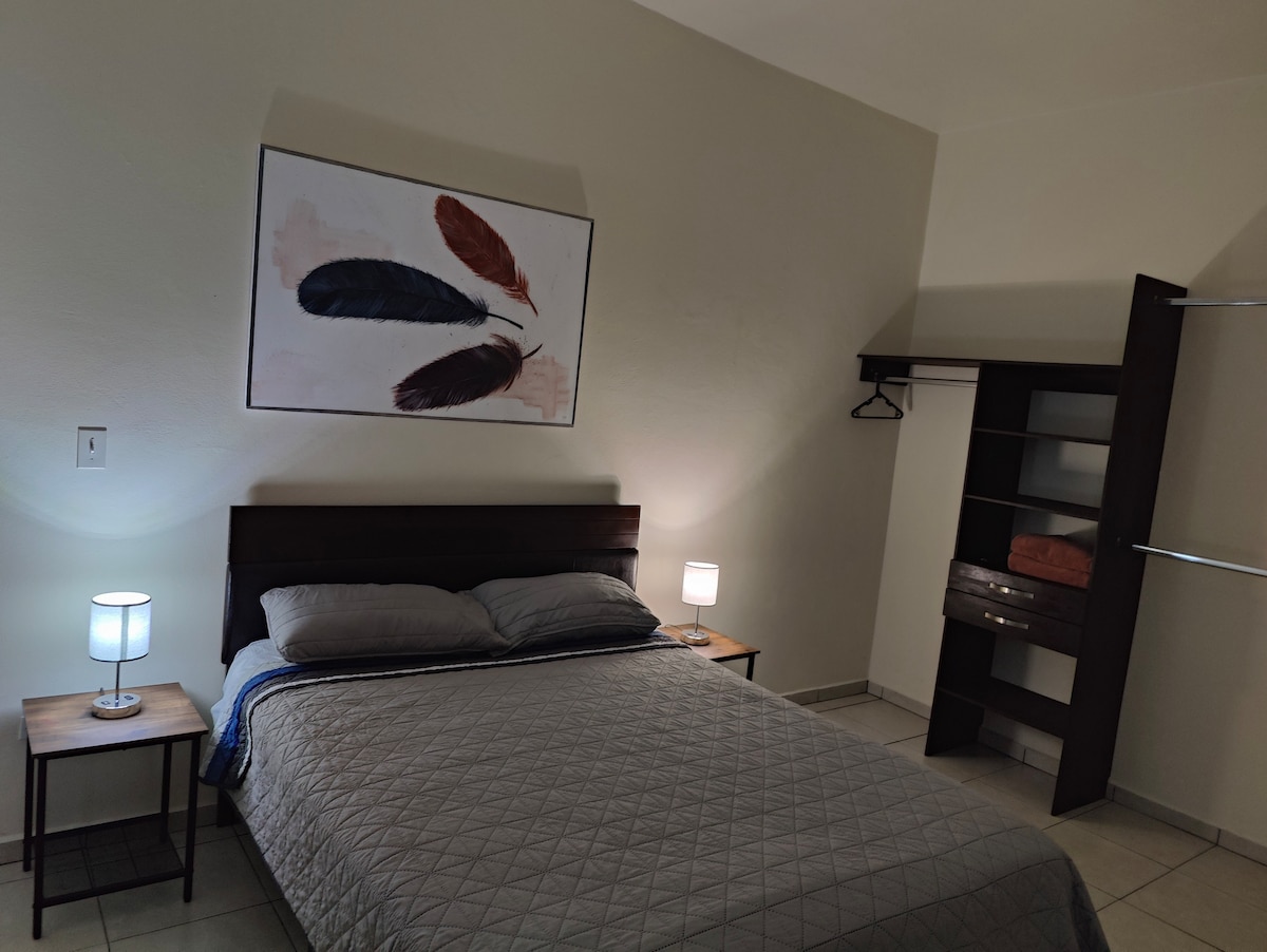 Recámara con cama queen, clóset, tv y aire acondicionado