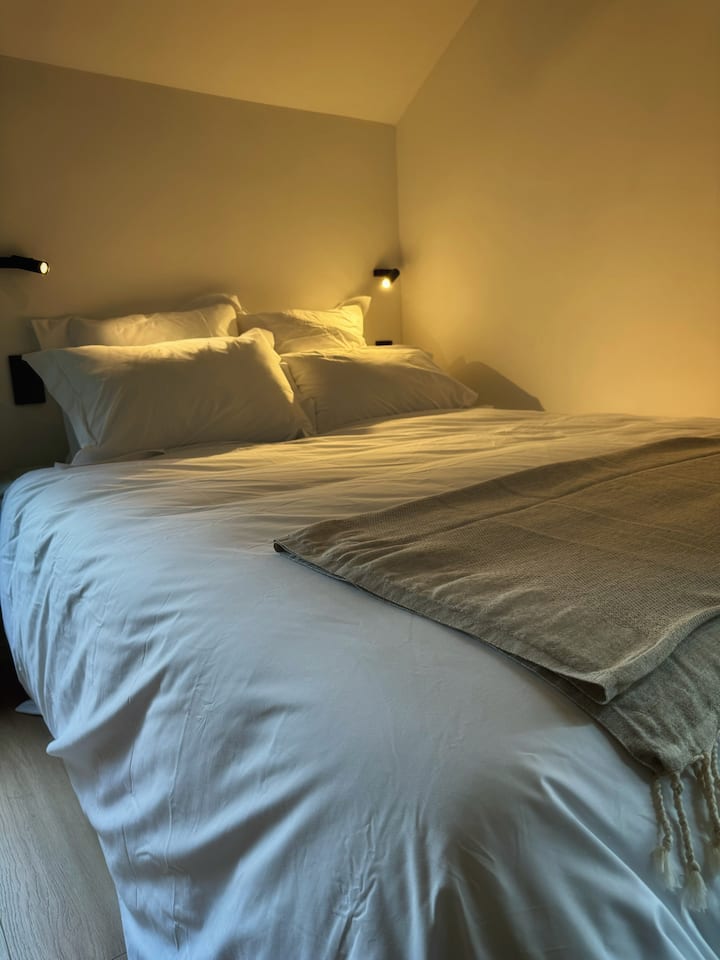 Stel je voor dat je in dit gezellige bed duikt, gesust door het geruis van het omliggende bos