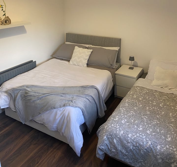 Segundo quarto com cama de casal e cama de solteiro pequena.