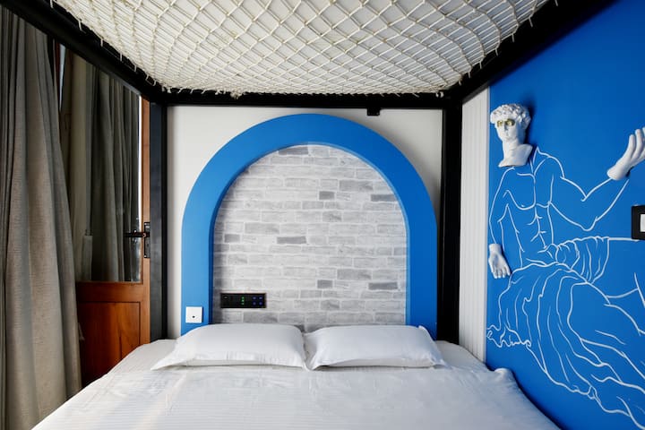 Safu ya juu ya kitanda cha ghorofa katika chumba hiki ni kipengele cha kuvutia na maridadi ambacho kinachanganya utendaji na ubunifu, kilichotengenezwa kabisa kwa kamba iliyosukwa.