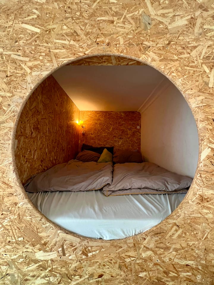 Para acceder a esta cama, sube al sillón de abajo y adéntrate en la cama. Ver foto.