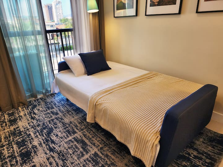 Ambiente versátil e acolhedor, com sofá-cama confortável e TV 32". Ideal para relaxar ou acomodar um terceiro hóspede.