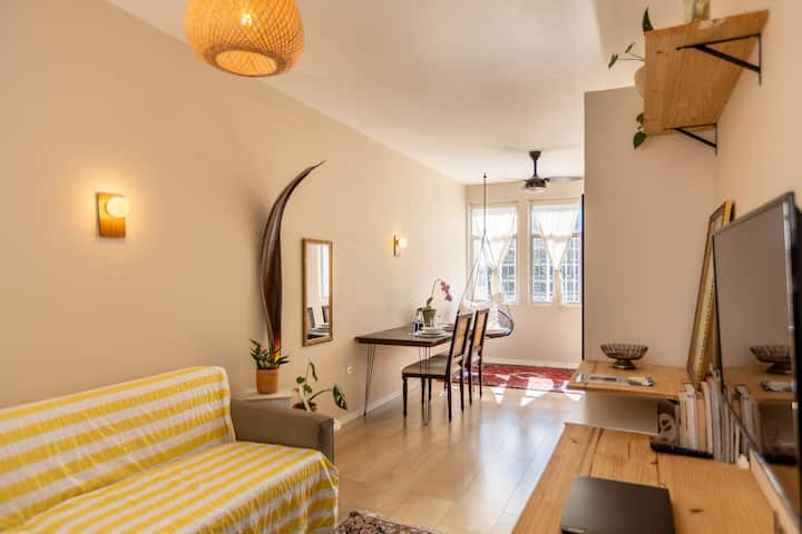 Sala de estar con un gran sofá de 3 plazas, Smart TV y escritorio. 