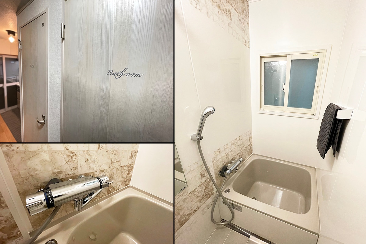 The bathroom features a modern design with a bathtub and a sleek faucet setup. A small window allows natural light while a towel is neatly hung nearby. A door labeled 'Bathroom' is visible, indicating easy access.