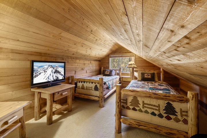 El loft es un espacio acogedor para dormir que cuenta con camas rústicas de troncos y un lugar cómodo para dormir. Es un refugio acogedor, perfecto para niños o amigos.  La televisión y la iluminación suave ofrecen mayor comodidad para relajarse después de un día de esquí o golf.