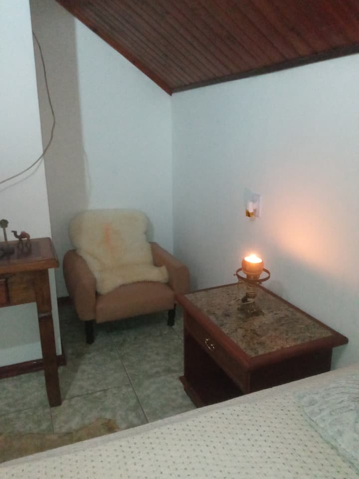 1 FAUTEUIL AVEC GRANULE DE MOUTON NATUREL, 2 TABLE DE CHEVET, 2 CHANDELIERS, 1 BUFFET AVEC TÉLÉVISION 32, AVEC 4 PIÈCES DE DÉCORATION SUR LE DESSUS, 1 BIBLE, 1 TAPIS RAM NATUREL SUR LE SOL, 1 RACK SUR LE MUR, 1 CADRE DE CHEVAL, 1 PHOTO DE LA BIBLE.