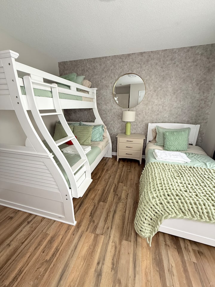  غرفة نوم مشرقة وواسعة مع سرير مزدوج وإعداد سرير بطابقين أنيق – مثالية للأطفال أو المجموعات.
