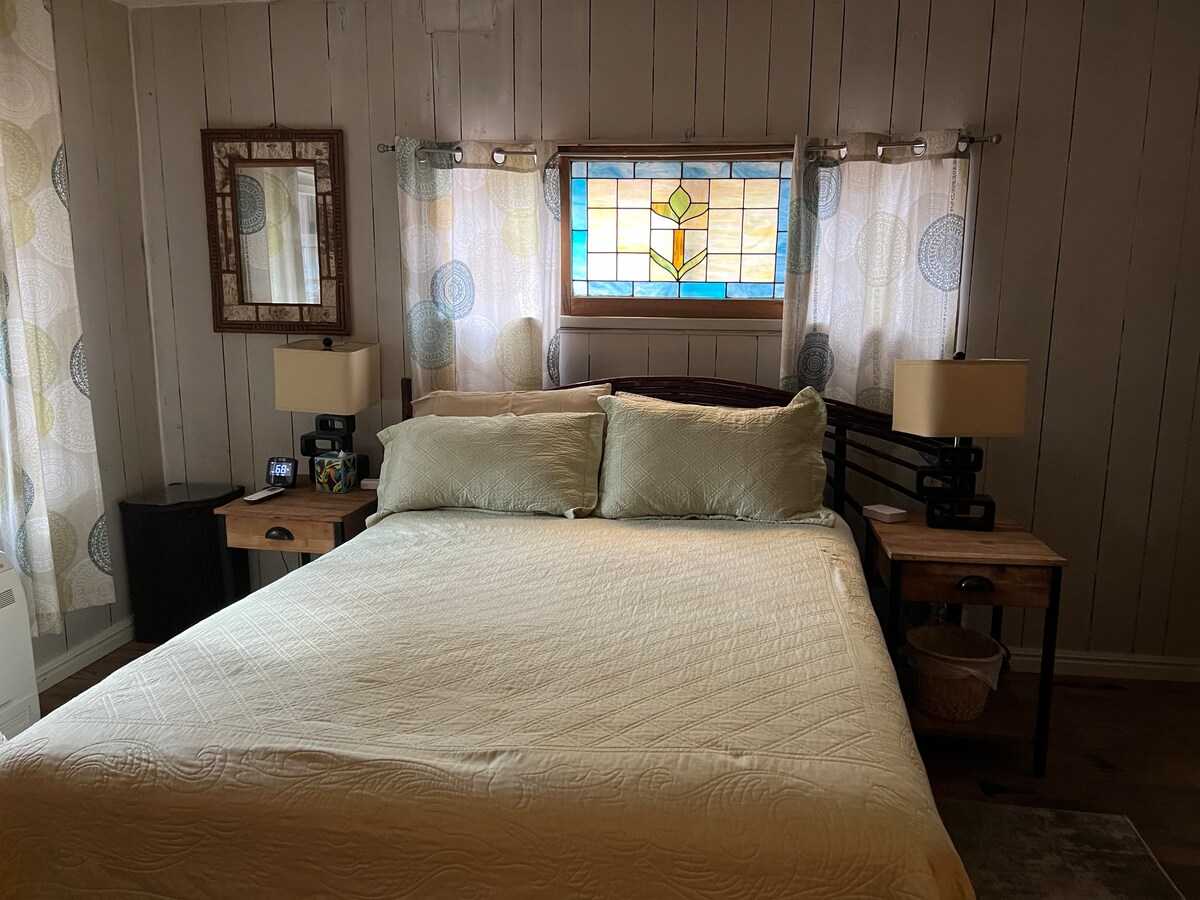 سرير كوين في غرفة النوم الرئيسية. لوح سرير من خشب الصفصاف، زجاج ملون عتيق فوق السرير. مفروشات خشبية صلبة تم بناؤها حسب الطلب من قبل زوجي ن*ك في متجرنا، أوربان ساوث ويست الداخلية في فينيكس أز. 85014. 