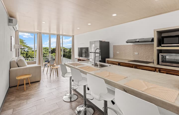 hapësirë e ndritshme, moderne dhe e hapur për të jetuar, e projektuar për mëngjese të ngadalta dhe mbrëmje të qeta. Çlodhu në një divan të rehatshëm, shijo televizorin inteligjent dhe shijo dritën natyrale. Dil jashtë dhe je në pishinën tënde private, ajër i pastër, pamje, tinguj të xhunglës