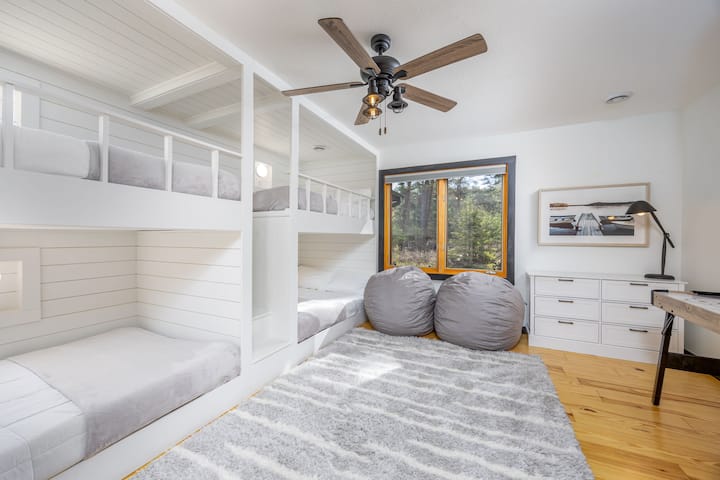 غرفة بطابقين مع 4 أسرّة كاملة الحجم وطاولة هوكي هوائي وأكياس فاصوليا وألعاب وكتب.