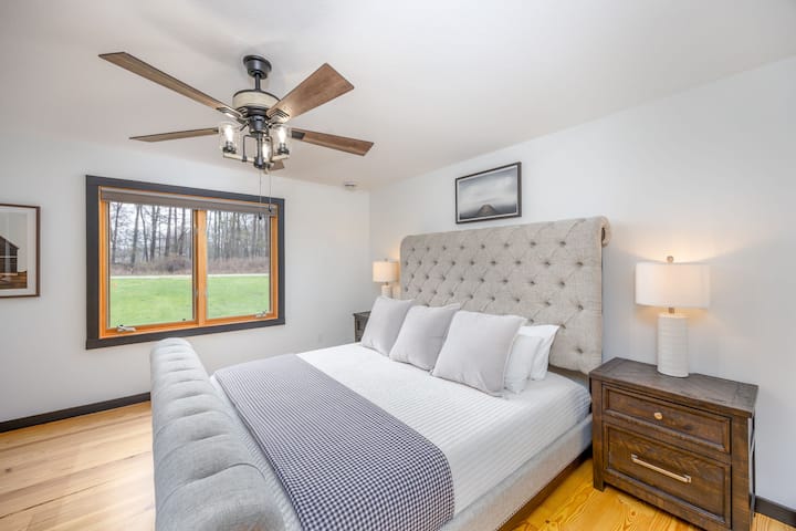 سرير كبير الحجم مع حمام داخلي ودش زجاجي وأحواض مزدوجة وتلفزيون ذكي ومساحة تخزين كبيرة. 