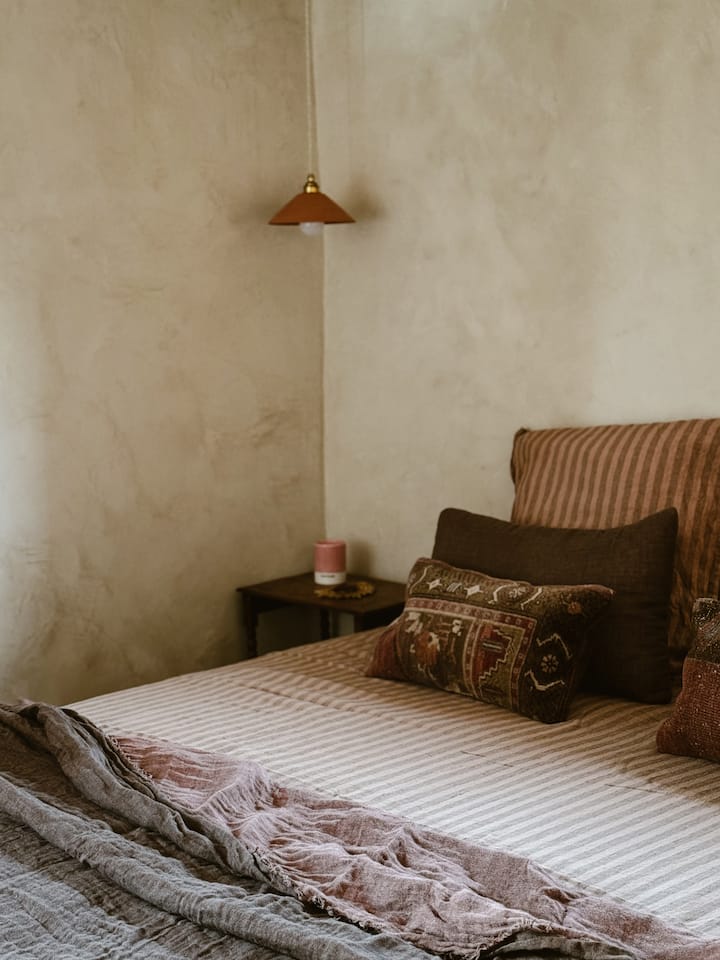 La flexibilité règne en maître, offrant la liberté de transformer les couchages en deux lits simples ou en un lit double. Les murs travaillés avec un enduit fin à la chaux et des pigments naturels dégagent une douceur subtile, invitant à la rêverie.