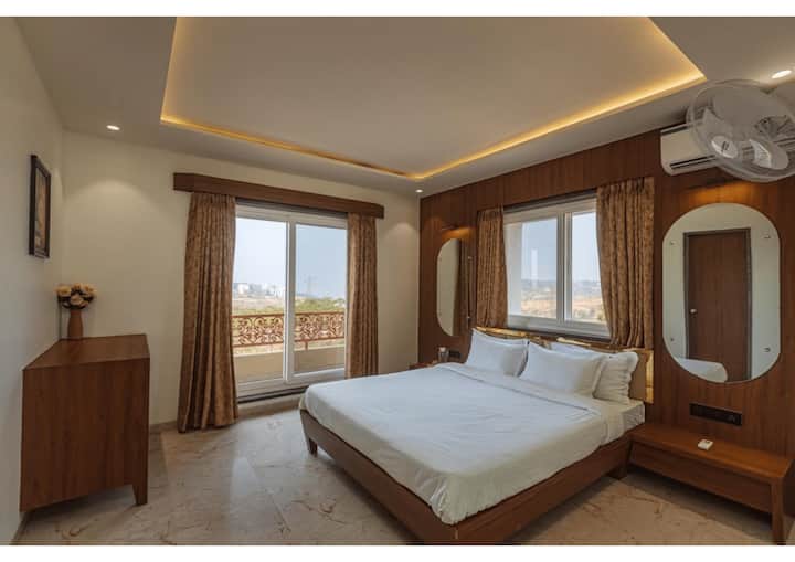 Kjo dhomë gjumi me ajër të kondicionuar ka shtroja të buta, dekor elegant, dritare të mëdha me perde të mëdha dhe një ballkon privat, duke krijuar një atmosferë të qetë dhe ftuese të mbushur me dritë natyrale.