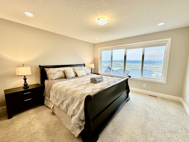 Hlavná spálňa - manželská posteľ s vlastnou kúpeľňou a šatníkom. Veľké okno s výhľadom  na mestskú a vzdialenú prírodnú scenériu.