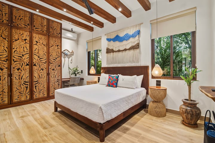 Dormitorio tamaño king en la planta baja con privacidad de los huéspedes en la planta superior y fácil acceso. Fresco y nítido con techos de más de 11', vistas al jardín, amplio espacio en el armario y un escritorio