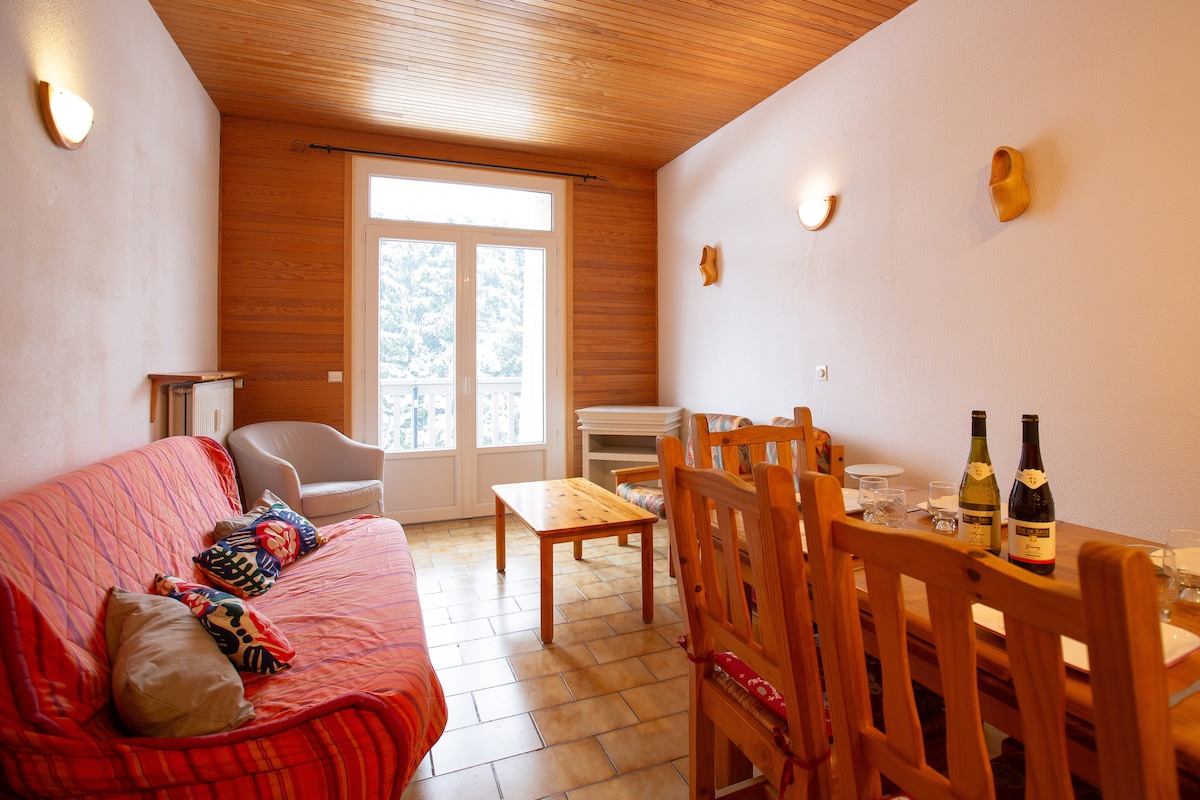 Sala de estar con vistas al balcón y a los abetos en la tranquilidad. Sala de estar y cocina equipada abierta a la sala de estar. Sofá convertible para 2 camas.