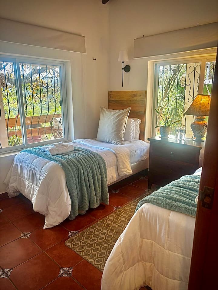 “Wake up to natural light, surrounded by forest, and with an unobstructed view of Mount Uyuca from the window of this room.”
