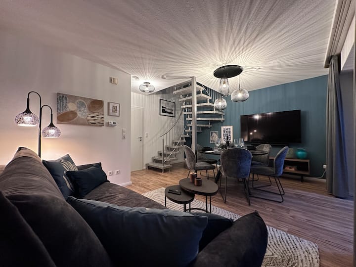 Sehemu ya kuishi na ya kula yenye ufikiaji kwenye ghorofa ya juu.