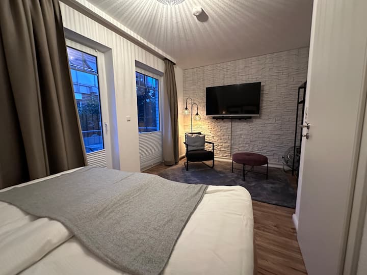 Chumba cha kulala kwenye ghorofa ya 1 chenye televisheni mahiri ya "55", upau wa sauti na roshani ya kujitegemea.