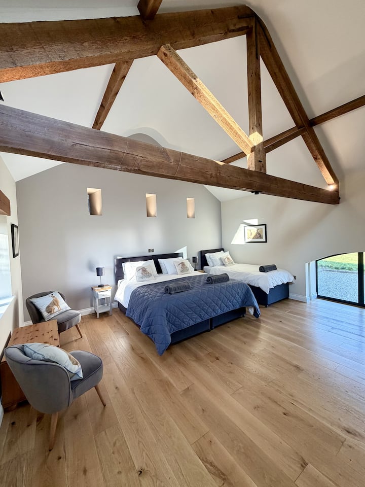 Original beams, arrow slits with feature lighting and the arched window show how the traditional features of the barn have been preserved in our hare themed room. You may be lucky and spot one of these elusive mammals on the lawn outside.