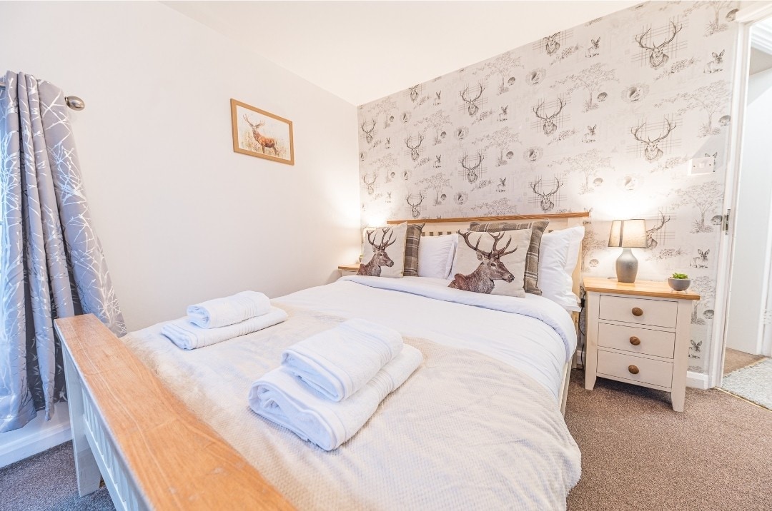 Zachte lichte en zachte stoelen maken deze slaapkamer een perfect toevluchtsoord voor rustgevende momenten.