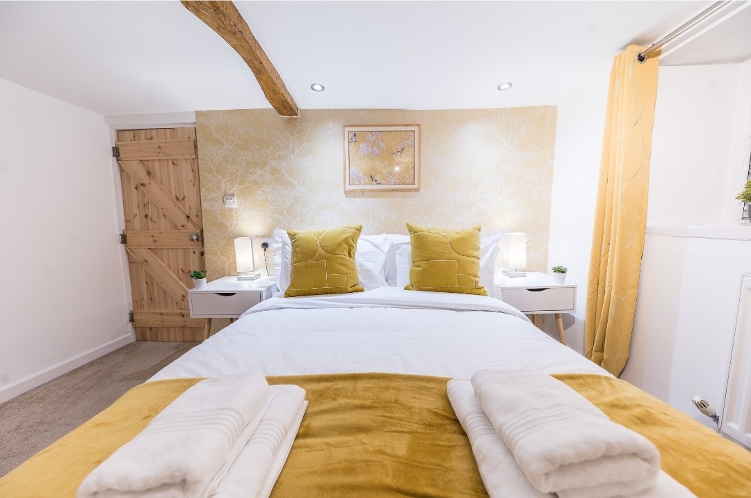 Waar comfort en stijl samenkomen: een gastvrij bed en rustgevende kleuren nodigen uit tot zoete dromen.