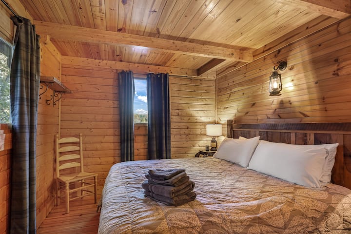 Chumba cha 1 cha kulala kina kitanda cha ukubwa wa kifalme chenye nafasi ya kutosha ya kujinyoosha na kupumzika.