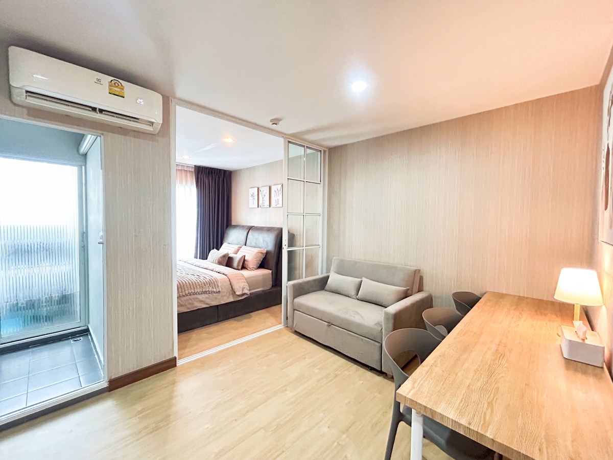 استرخ في غرفة المعيشة المريحة الخاصة بنا، التي تحتوي على أريكة تتحول إلى سرير مع وسائد وبطانية، وتلفزيون ذكي للبث، وتكييف هواء للحفاظ على هدوئك بعد استكشاف بانكوك.