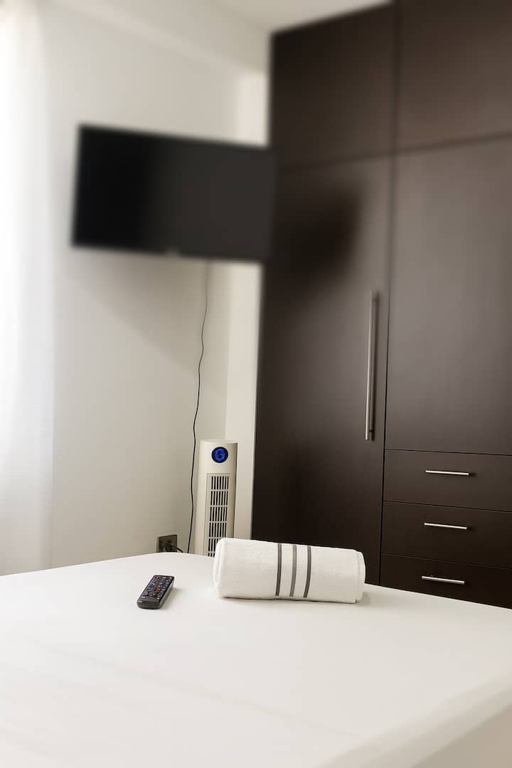 تحتوي الغرفة على سرير مزدوج وتلفزيون وخزانة ملابس واسعة ومروحة لمزيد من الراحة. مساحة دافئة وعملية، مثالية للراحة والاستمتاع بإقامة مريحة مع كل ما تحتاجه في متناول يدك.