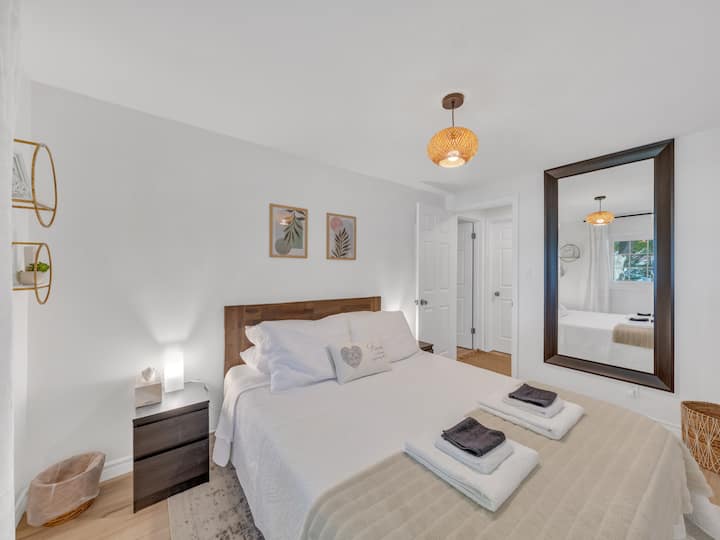 חדר שינה נעים ומאוורר עם מיטת קווין סייז נוחה, עם מראה גדולה. 