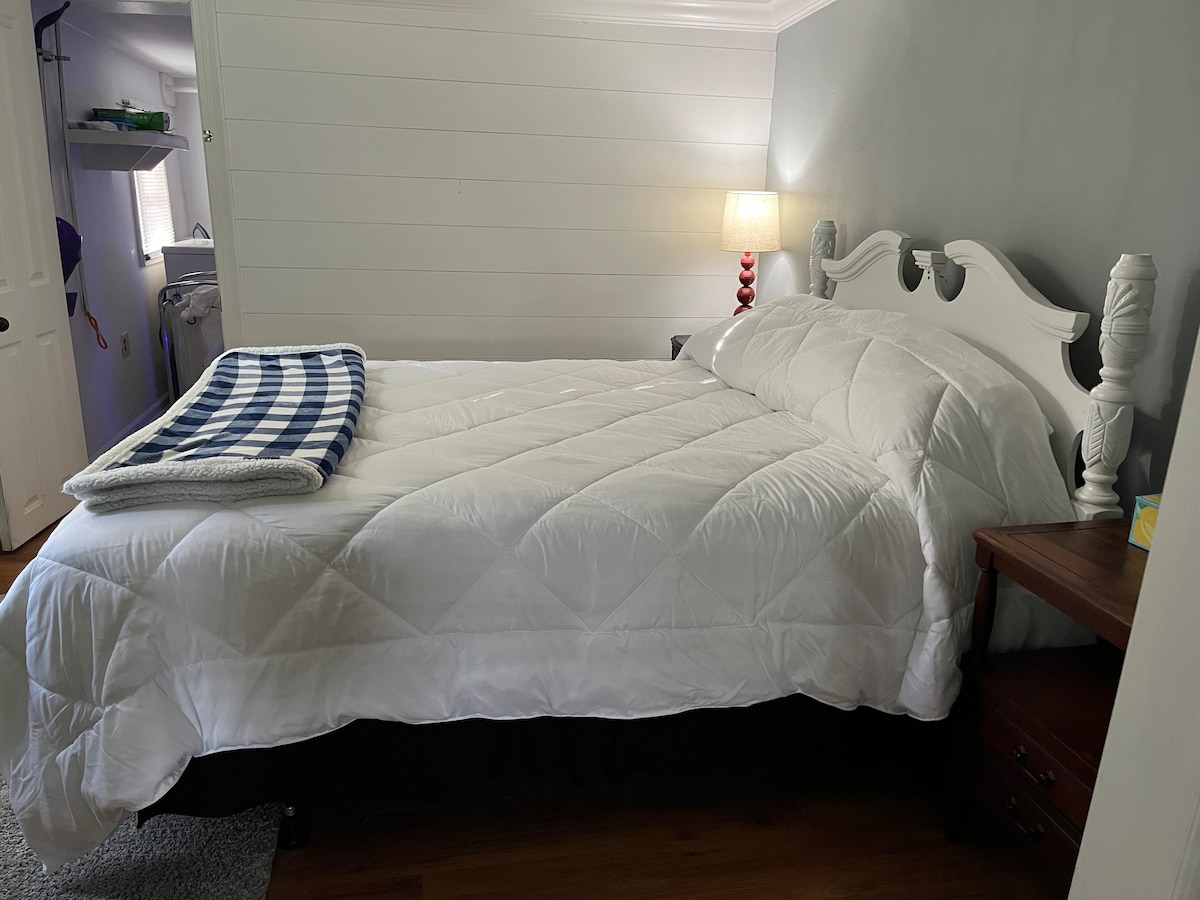 Queensize bed met bamboe of 100% katoenen lakens en donzen Serra dekbed en kussens. 