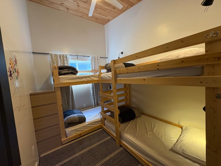 2 Bunkbeds - sleeps 4. Room darkening curtains, ceiling fan, clothing storage, knotty pine high sloped ceiling. (Mini crib may be available upon request and is suitable for this space.)