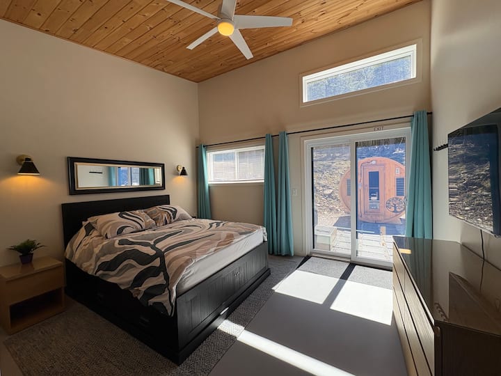 Queen Bed, access to hot tub, sauna &backyard. Ceiling fan, Roku TV, room darkening curtains, but high transom window isn't covered so you can see stars on a clear night! (Mini crib may be available upon request and is suitable for this space.)