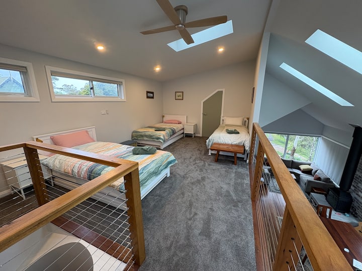 Área de loft/entrepiso con 3 camas individuales más dos camas nido. Ten en cuenta que esta zona mira hacia abajo en la sala de estar principal 