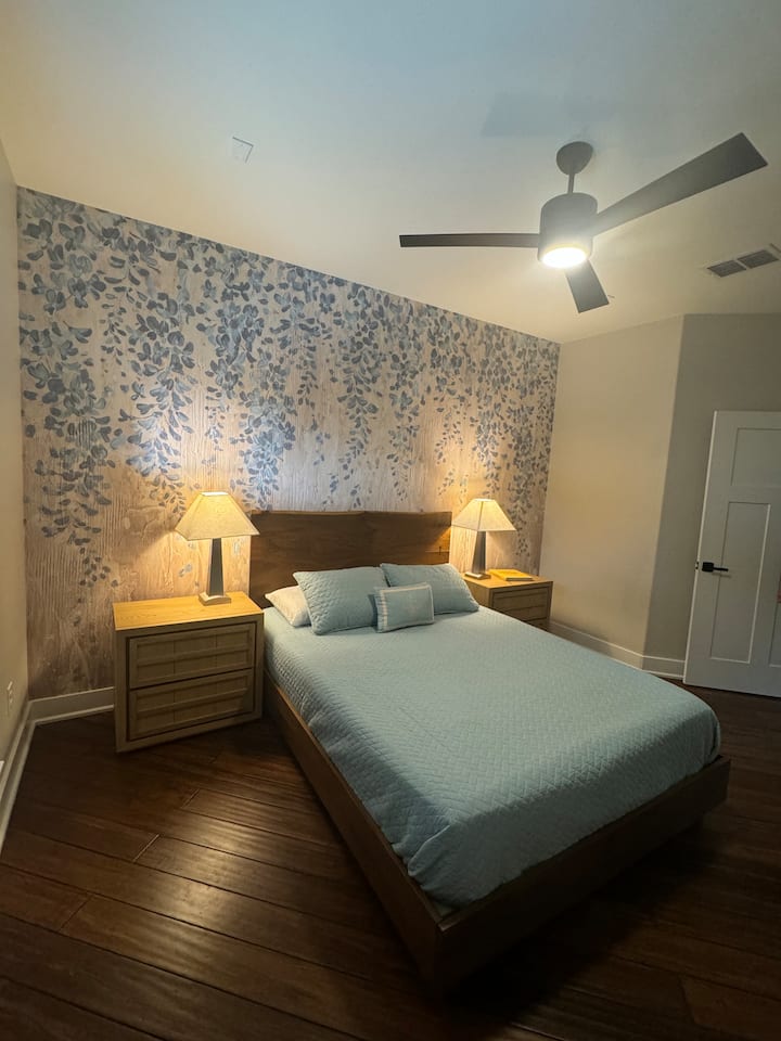 Feel like royalty in this beautiful queen room with a ceiling fan and a wildflower themed wall reminiscent of Texas bluebonnets. A full bathroom with custom tiled shower is conveniently located next door. 
