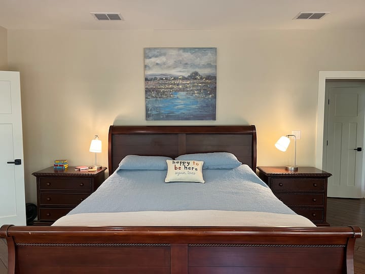 This main floor primary king suite with full-sized television includes direct patio access with lake views and a luxurious en suite bathroom for your private retreat. 
