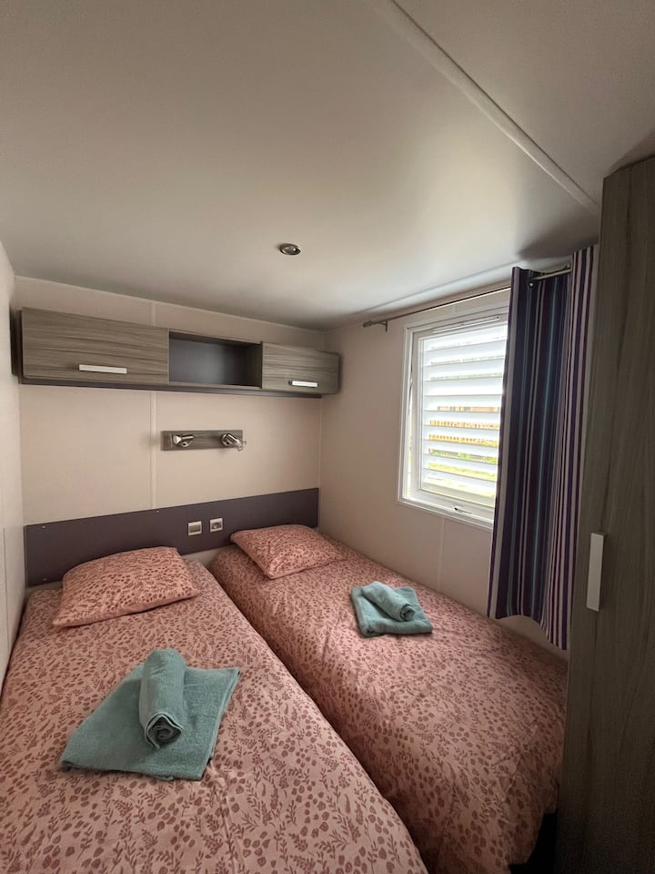 Bedroom with 2 single beds, towels, sheets, duvet