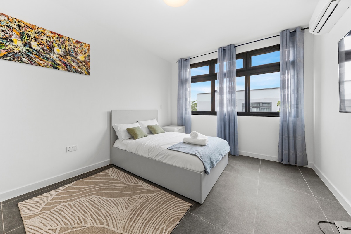 غرفة نوم ثانية مريحة تتميز بسرير مزدوج ومكيف هواء وبياضات ناعمة لنوم رائع. تسمح النوافذ الكبيرة بدخول الضوء الطبيعي. يخلق الديكور العصري والتخزين بجانب السرير مساحة هادئة مثالية للأزواج أو المسافرين المنفردين.