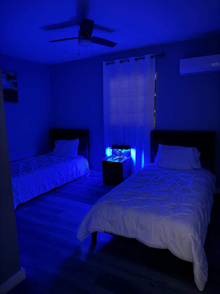 มีเตียงแฝด 2 หลังและตู้เสื้อผ้าพร้อมไม้แขวนเสื้อ พัดลมเพดานและไฟ LED ทั้งหลังสมาร์ททีวีขนาด 55 นิ้วบนผนังนอนได้ 2 คนสบายๆ