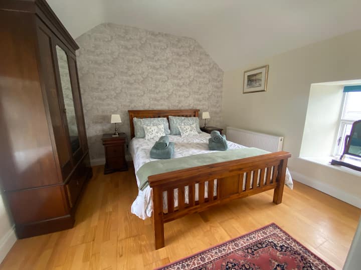 Cama tamaño king con ropa de cama y toallas de primera calidad, armario con cajones, baño con ducha instantánea
