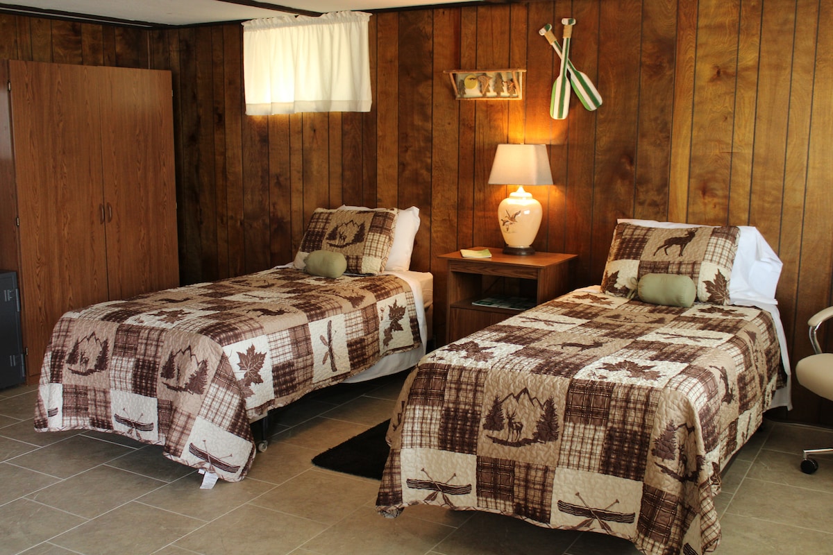 Twee eenpersoonsbedden, bijzettafels en hang- en opbergkast. 