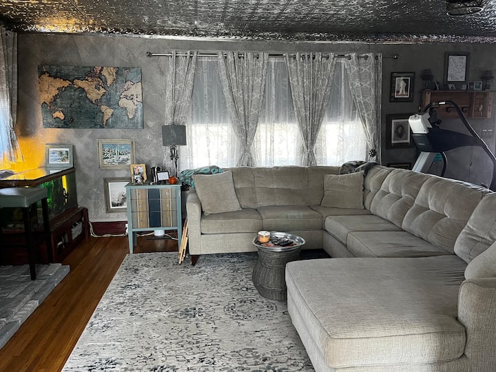 Obývacia izba na hlavnom poschodí s pohovkou v tvare L pohodlná na spanie pre dvoch. Na spanie použite plachty v koši. Akvárium so skalárom a žralokmi balamskými. Bežecký pás na cvičenie v interiéri. Elektrický kábel pod pohovkou na nabíjanie telefónu, iPadu. 